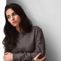 traurige Frau, die steht und in die Ferne schaut