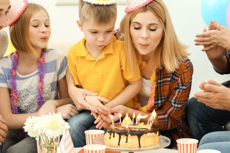 lehrer bläst kerzen mit kindern aus