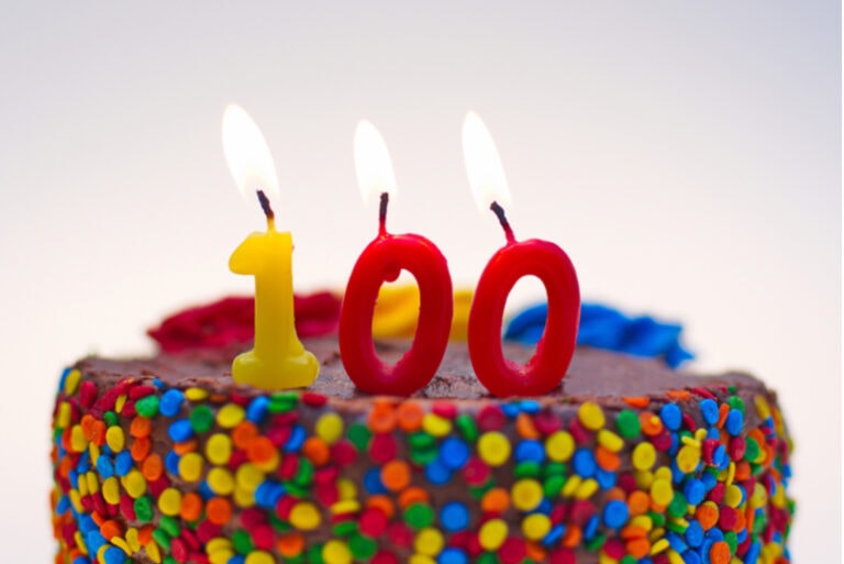 Kerzen auf einem Kuchen mit der Zahl 100