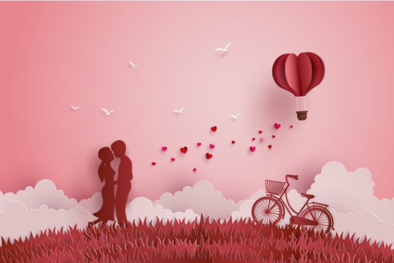 Verliebte standen auf den Wiesen und ein herzförmiger Papierballon schwebte am Himmel