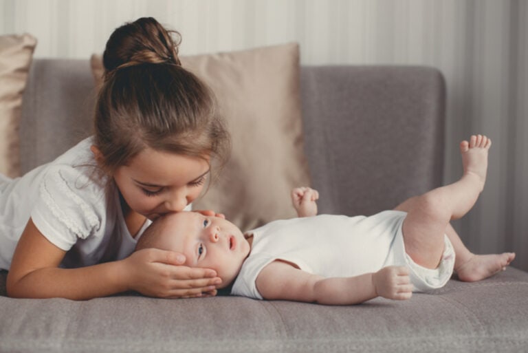Schwester, die ihren kleinen Bruder küsst