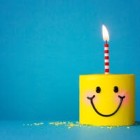 Gelber Happy Face Geburtstagskuchen mit einer Kerze