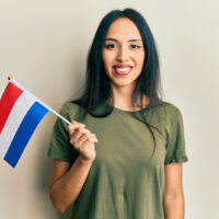 eine Frau, die die Flagge der Niederlande hält