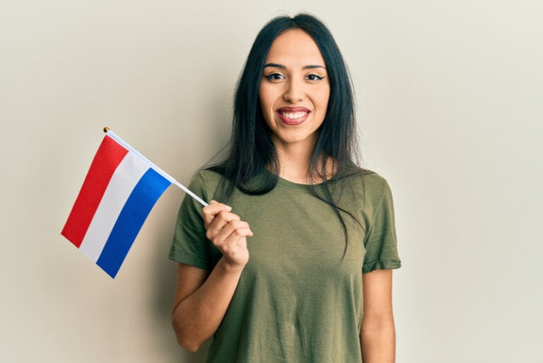 eine Frau, die die Flagge der Niederlande hält