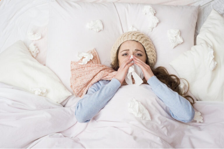 Kranke Frau, die mit hohem Fieber im Bett liegt