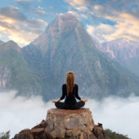 Frau, die Yoga auf dem Berg praktiziert