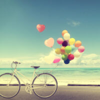 Vintage Fahrrad mit Herzballon am Strand