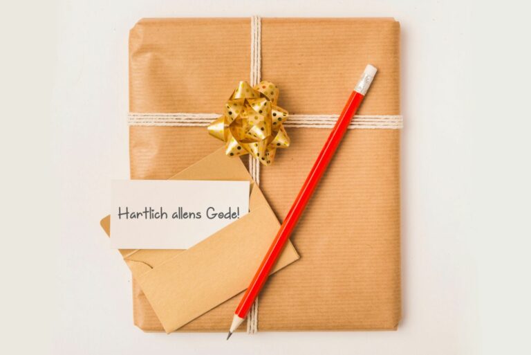 Geburtstagsgeschenk und eine Karte mit einem handschriftlichen Geburtstagswunsch auf Plattdeutsch