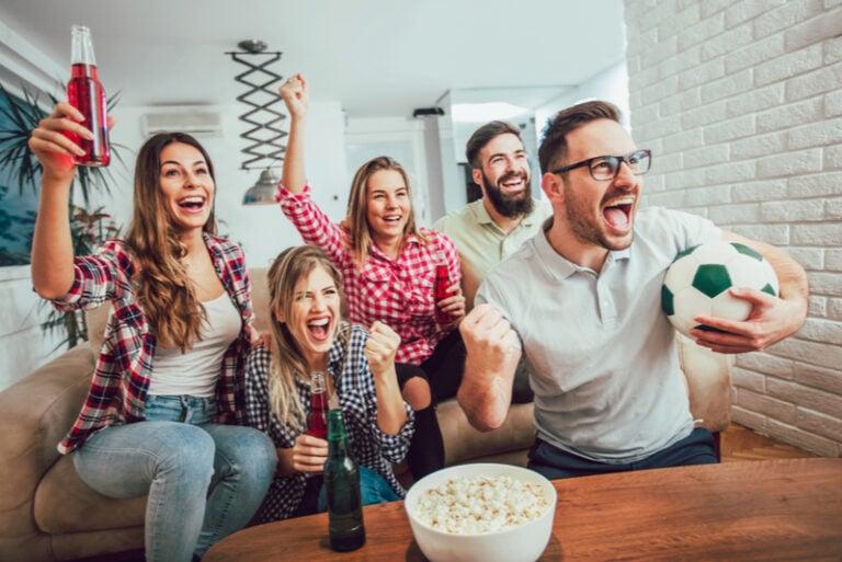 Fröhliche Freunde oder Fußballfans, die Fußball im Fernsehen sehen