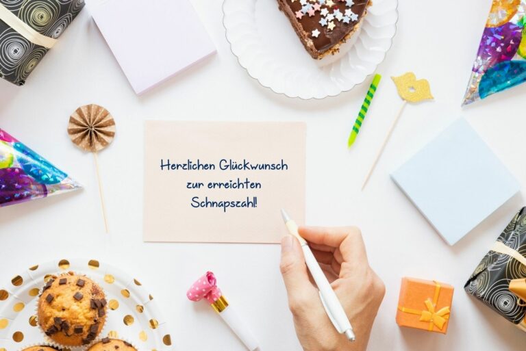 Person schreibt " Herzlichen Glückwunsch zur erreichten Schnapszahl" auf eine Karte