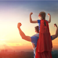 Papa und Kind im Kostüm eines Superhelden