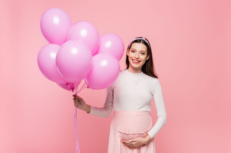 Schwangere Frau mit Luftballons