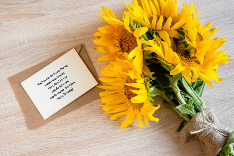 handgeschriebene Geburtstagskarte auf dem Tisch neben wunderschönen Sonnenblumen