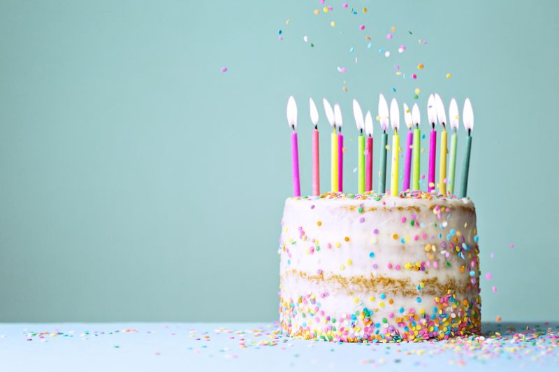 Naked Funfetti Geburtstagstorte mit bunten Kerzen und fallenden Streuseln