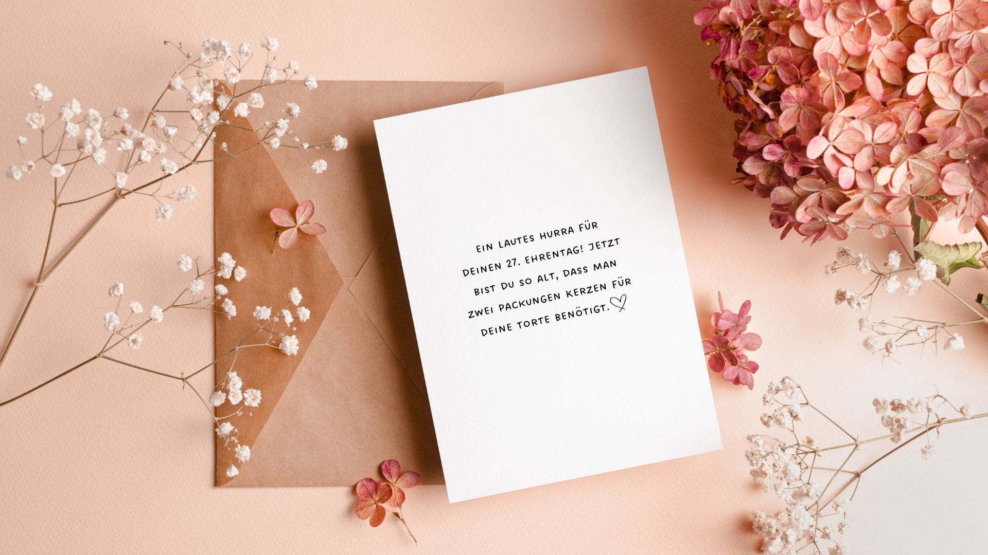 Blumenschmuck und eine Karte mit einem lustigen Wunsch zum 27. Geburtstag