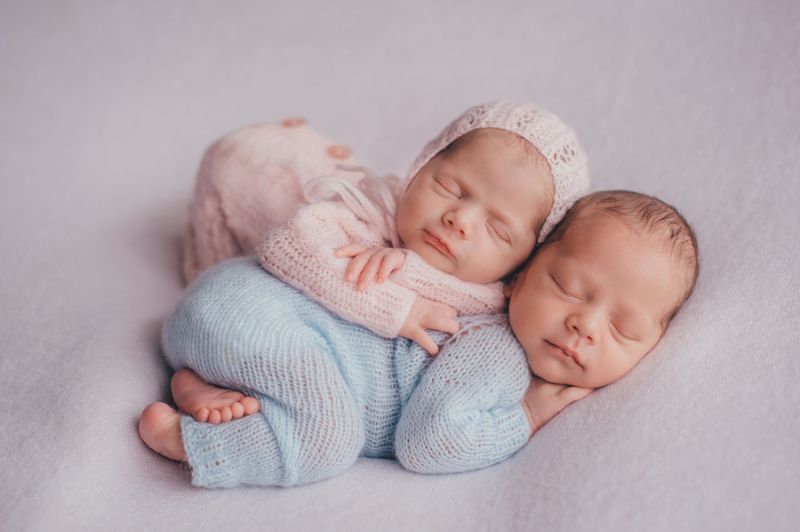 süße neugeborene zwillinge, die in einer umarmung schlafen