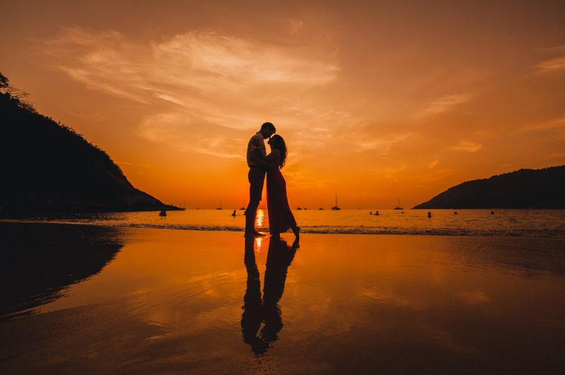 Paar küsst sich bei schönem Sonnenuntergang